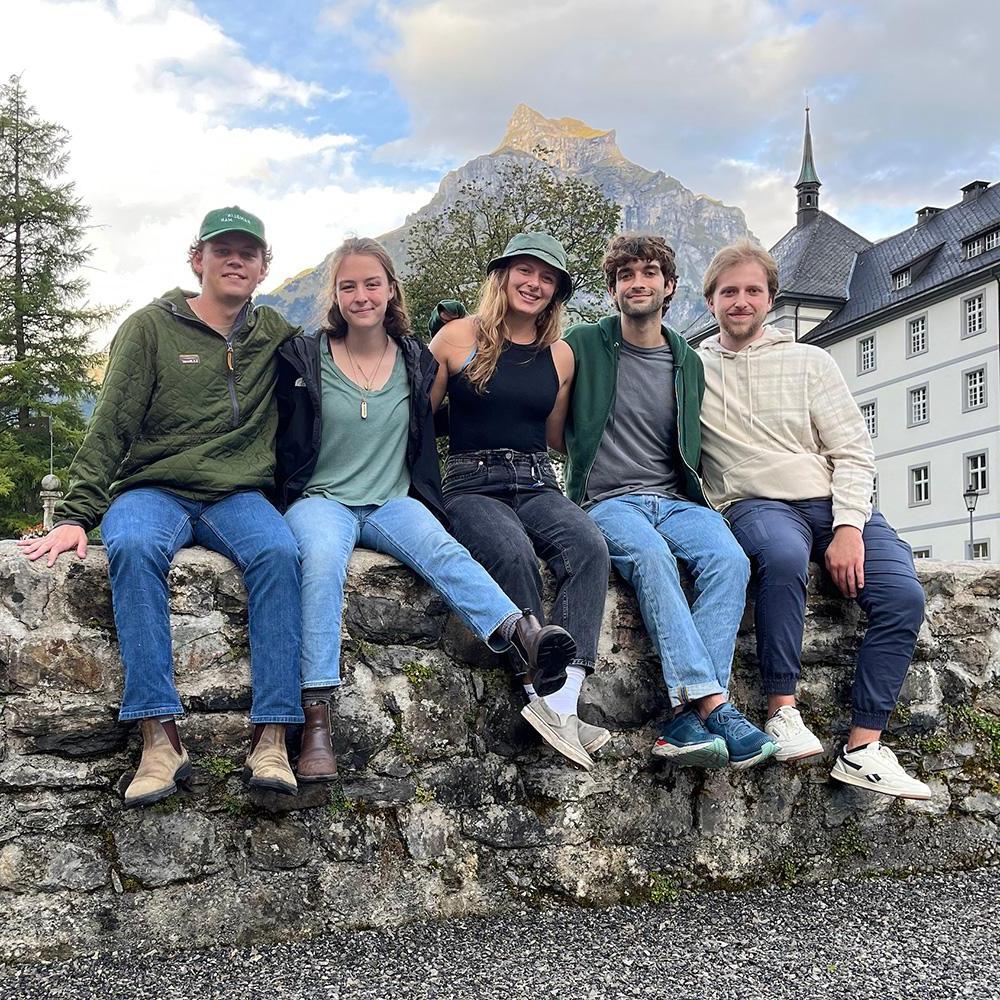 Five individuals pose for a photo during a tour of Switzerland.