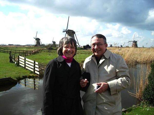 Man and woman standing in front of windmills