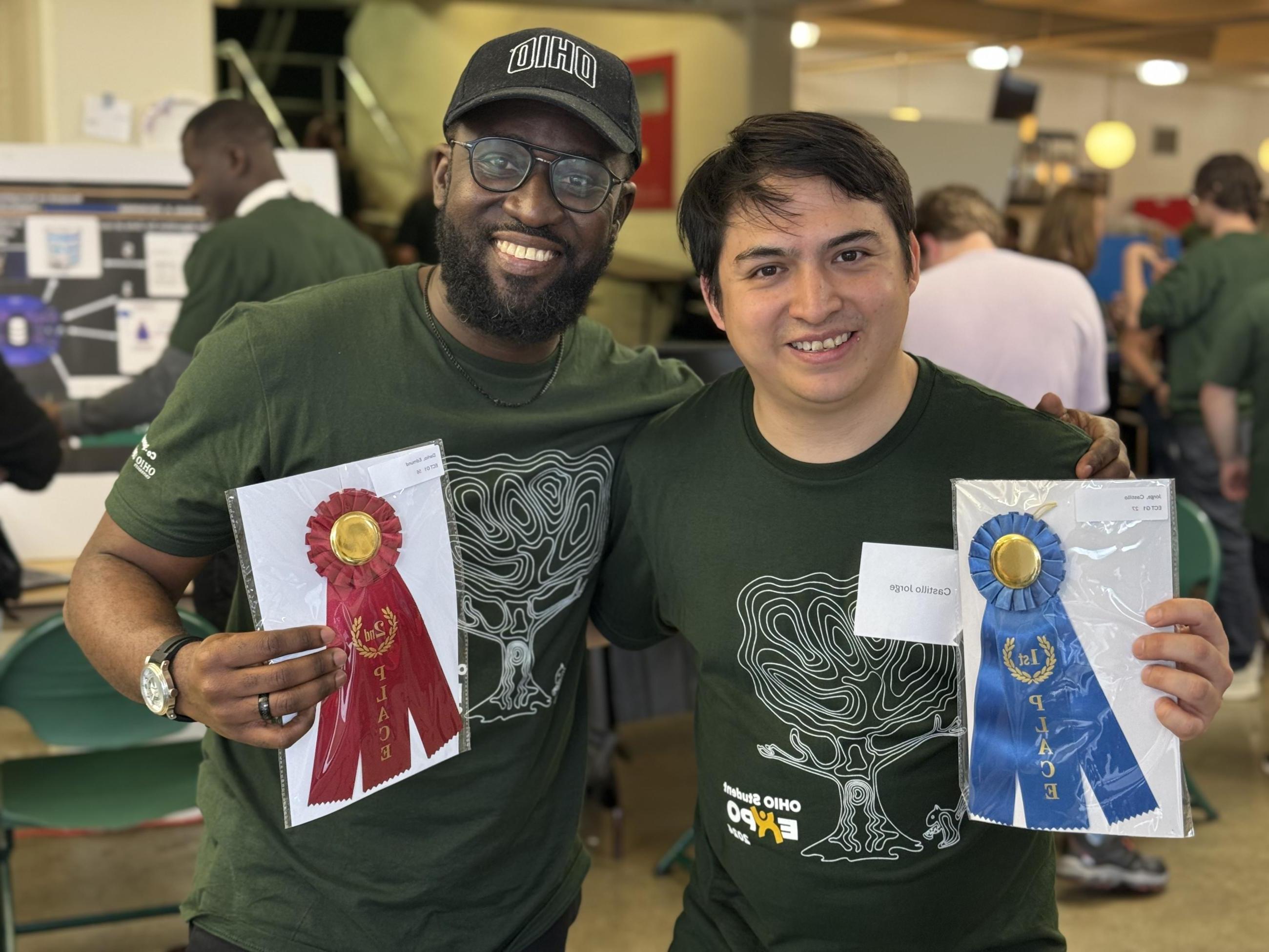 A shot of two students holding awards