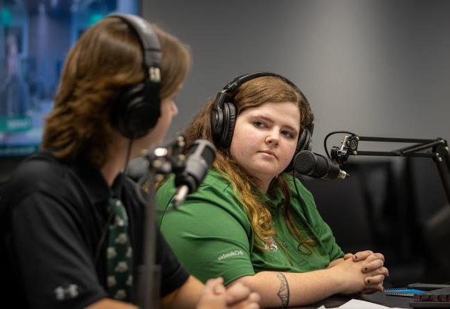 Two students speak into a microphone during an Ohio University Esports broadcast